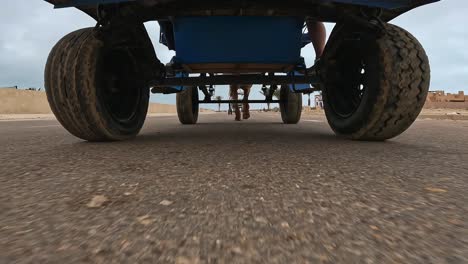 Low-angle-view-of-horse-drawn-carriage-traveling-down-asphalted-road