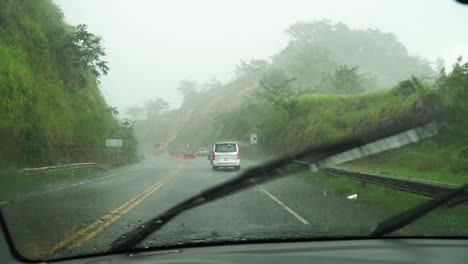 car driving really slowly because of heavy rain fall in the rainy season in costa rica