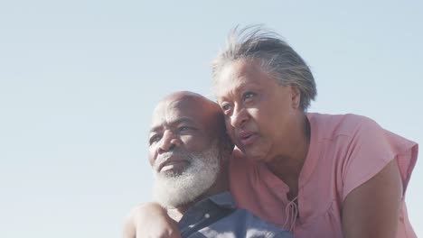 Happy-senior-african-american-couple-embracing-on-promenade-by-the-sea,-slow-motion