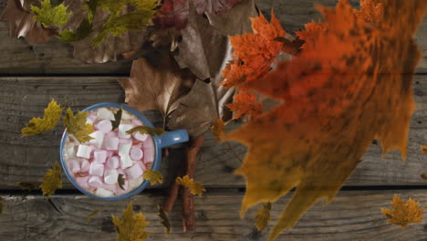 animación de malvaviscos de halloween en taza sobre hojas de otoño en fondo de madera.