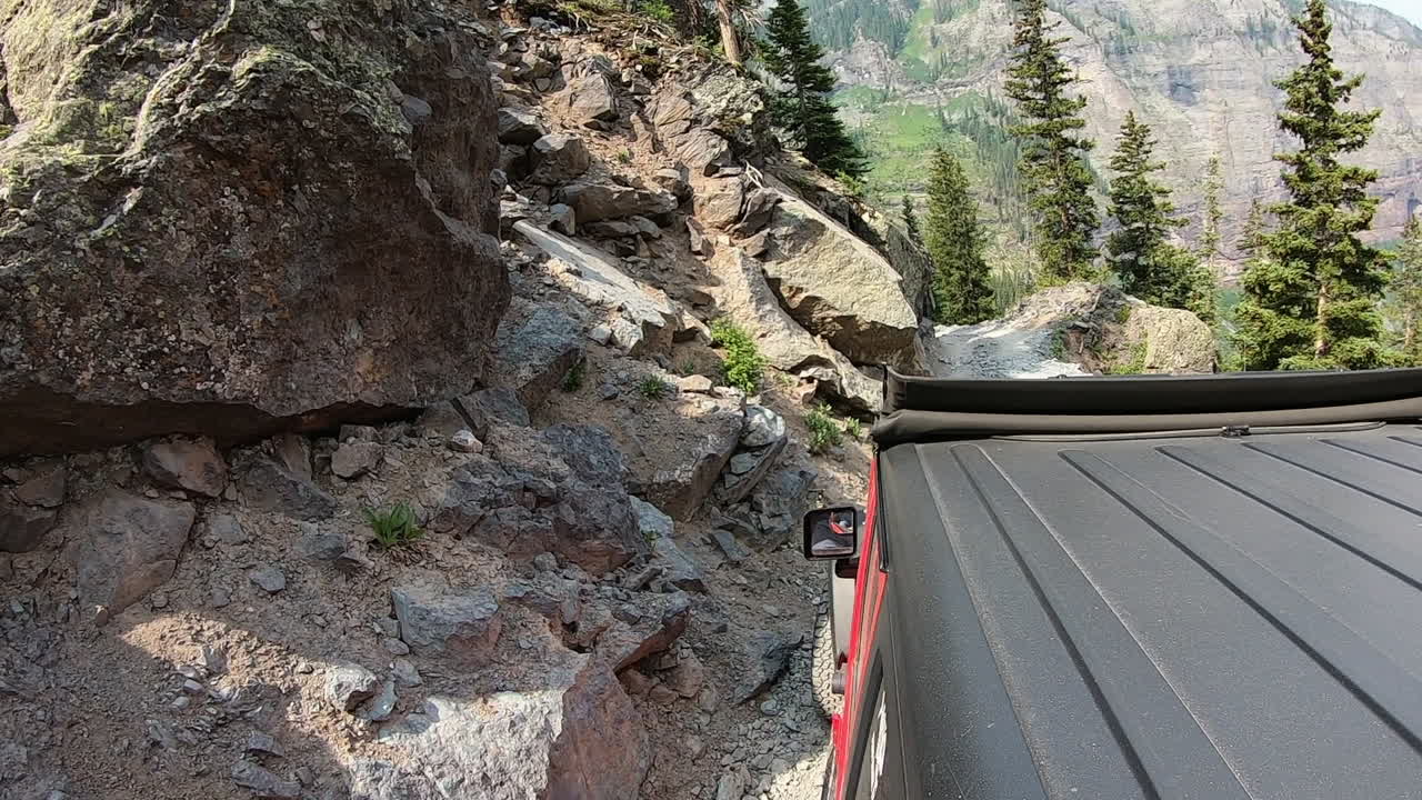 ouray colorado 근처의 san juan mountains에있는 poughkeepsie gulch 위의 산쪽으로 자른 트레일에서 운전하는 4wd 차량의 옥상