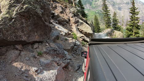 Rooftop-of-4WD-vehicle-driving-on-trail-cut-into-mountain-side-above-Poughkeepsie-Gulch-in-San-Juan-Mountains-near-Ouray-Colorado