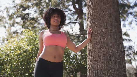 slim black woman stretching legs in park