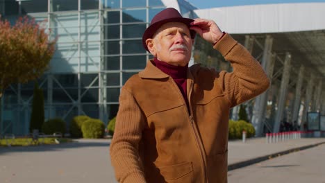 retrato de un hombre jubilado turista cerca de la terminal del aeropuerto esperando abordar un avión para viajar