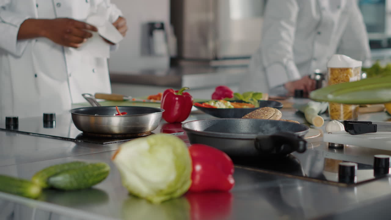 Professional cook preparing beef steak in frying pan on kitchen stove