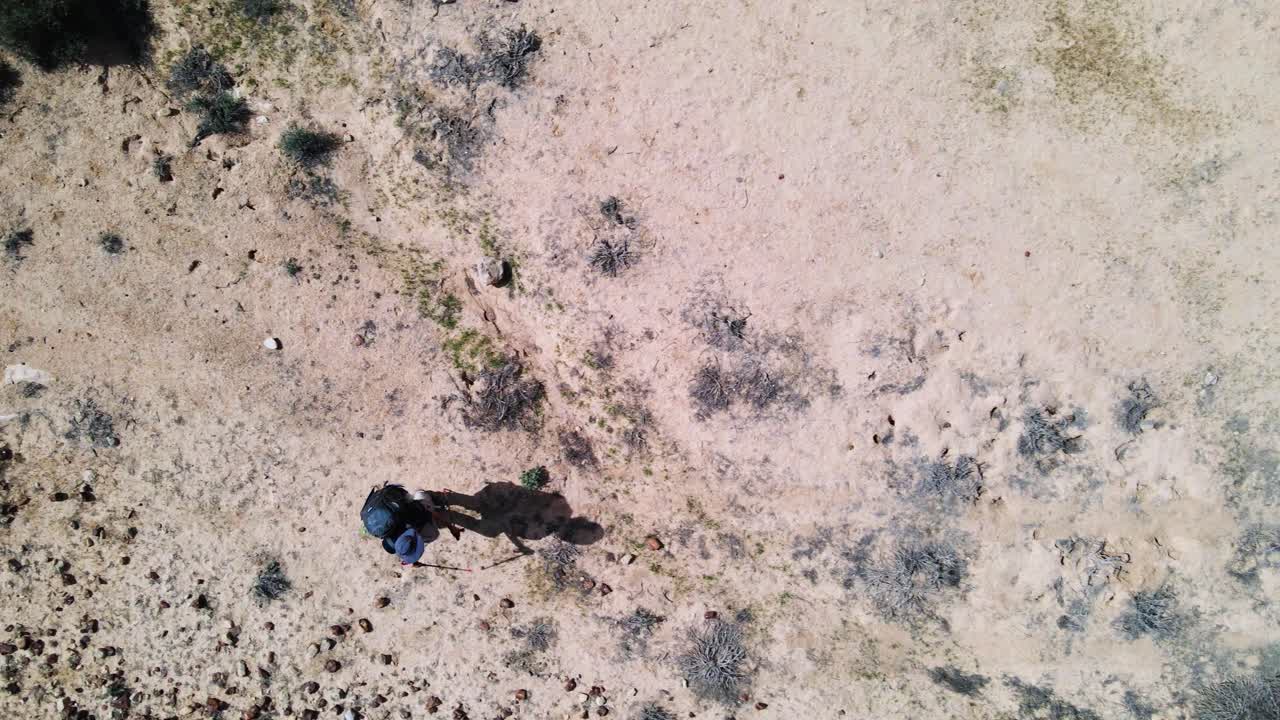 트랙을 따라 걷는 사막에서 등산객의 하향식 드론 샷