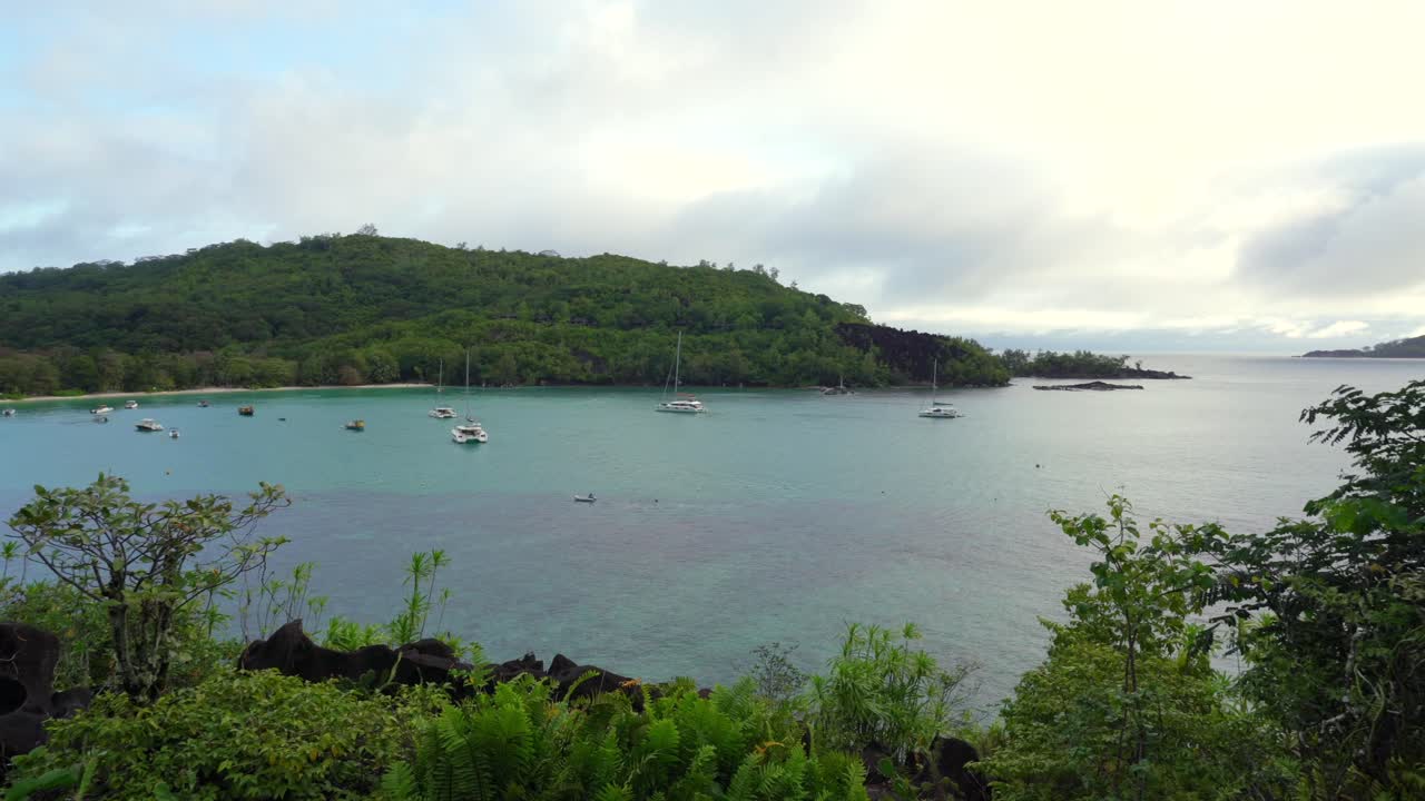 View of port launay beach and docking catamarans, yachts and boats, Mahe, Seychelles 30fps