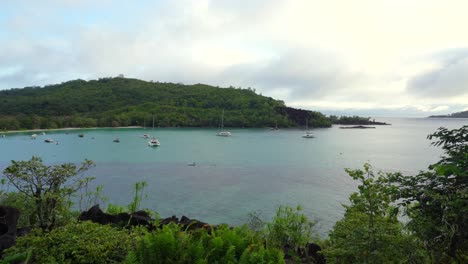 View of port launay beach and docking catamarans, yachts and boats, Mahe, Seychelles 30fps