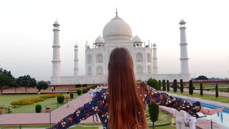 slow motion (120 fps): beautiful young lady enjoying the beauty of taj mahal in agra, india during the sunrise