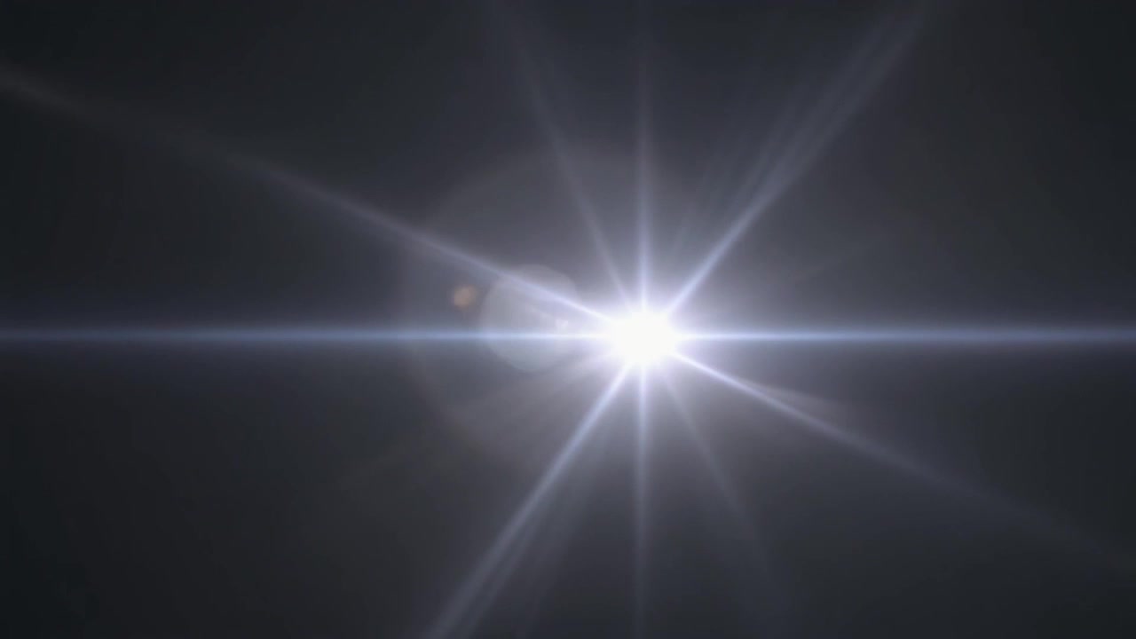Bagliore dell'obiettivo bianco brillante che si muove su sfondo scuro