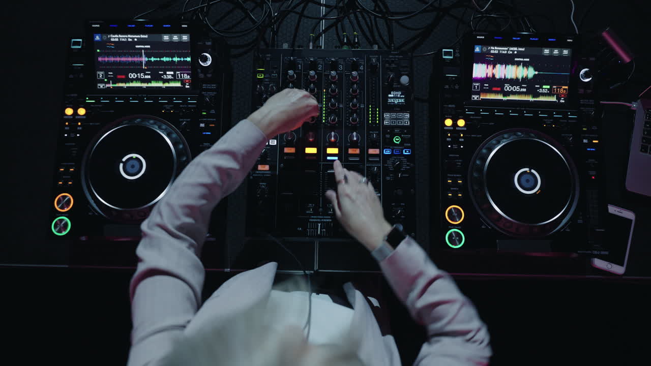 dj mezclando música en tocadiscos y mezcladores en un estudio