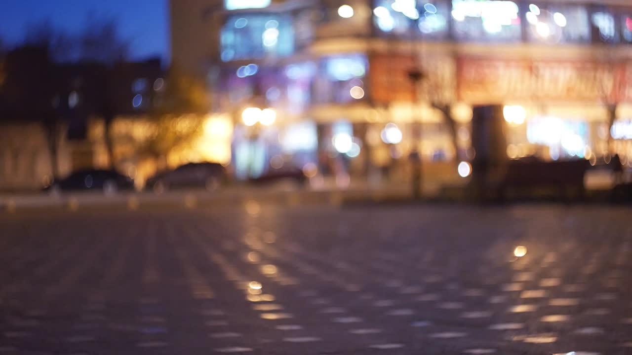 bokeh anamórfico cinematográfico con calle de la ciudad nocturna a la luz de faros y linternas