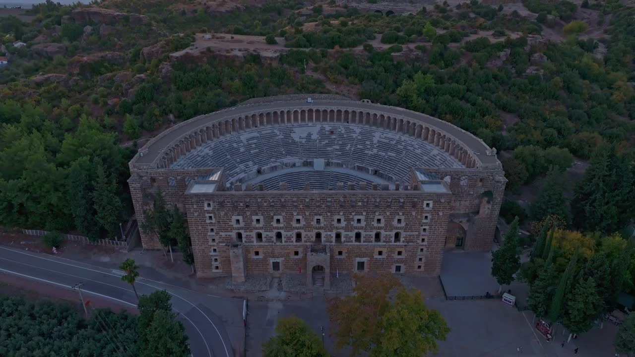Sedute in pietra di Aspendos illuminate al tramonto a Serik, Turchia