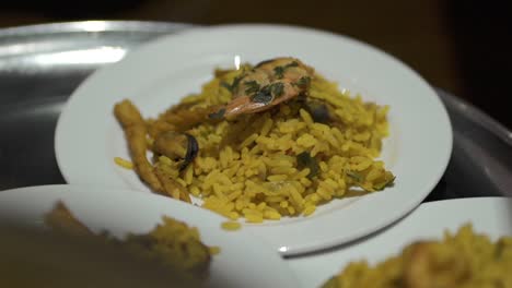 several paella dishes in detail on a tray, ready to be served at the table - close up