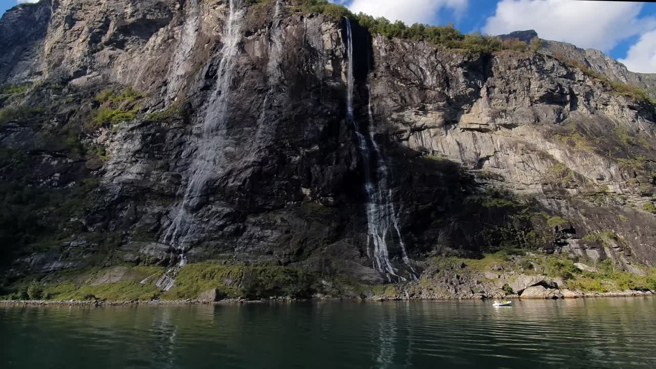 노르웨이의 7 자매 폭포 (seven sisters waterfall) 에 있는 게이랑거 피오르드 (geiranger fjord) 의 높은 바위벽.