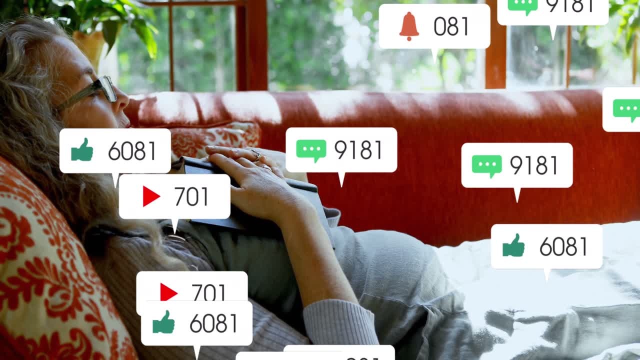 animación de múltiples iconos de las redes sociales sobre una mujer mayor caucásica con un libro tendido en el sofá