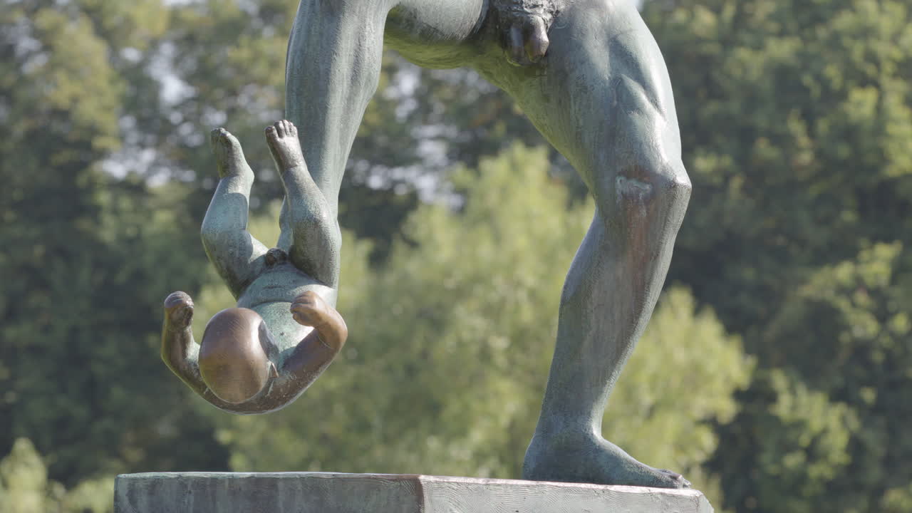 Tilt down reveal to the baby being kicked in Man Under Attack, Vigeland Park