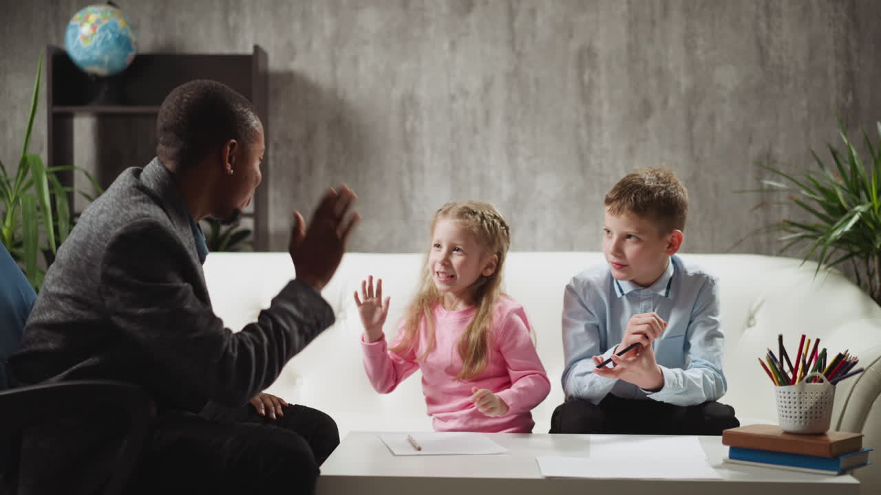Girl student gives high five to teacher studying with boy