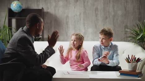 Eine-Schülerin-Gibt-Der-Lehrerin,-Die-Mit-Einem-Jungen-Lernt,-Ein-High-Five