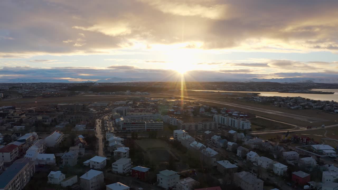 A Drone Flies Right over Residential Reykjavik House Rooftops during a Beautiful Sunset, Aerial Lens Flares, Iceland