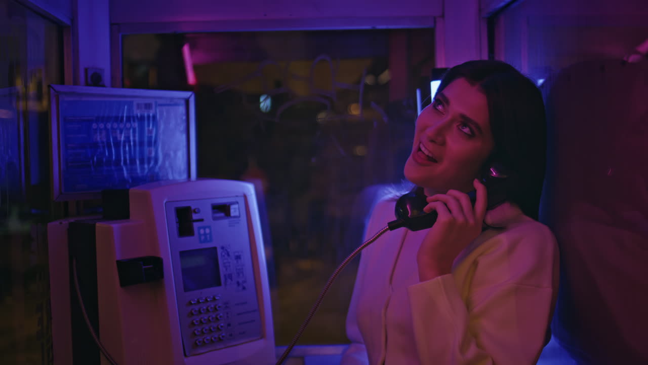 Sexy girl enjoying night in neon light call box portrait. Model looking camera