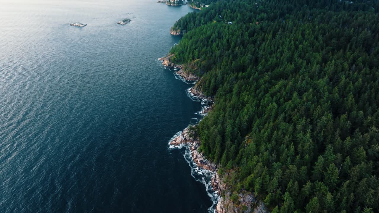 Slow up Pan drone footage of Pacific Northwest coastline, rich green forest to blue ocean