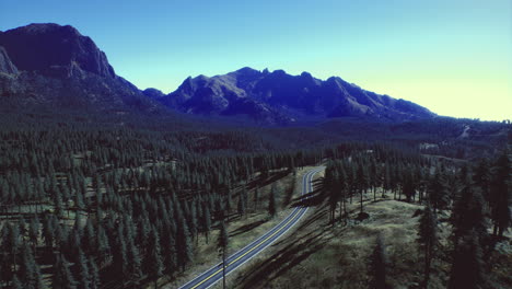 scenic mountain road winding through forested landscape at midday