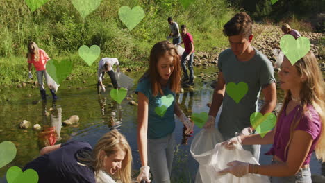 animation of green hearts over diverse happy group picking up rubbish in countryside