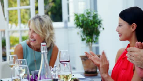 Friends-applauding-woman-while-having-meal