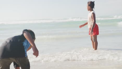 african american brother and sister jumping and enjoying at the beach