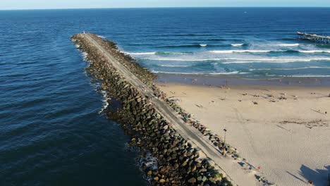 panning right looking out over rock wall and sand pumping jetty sunset,gold coast