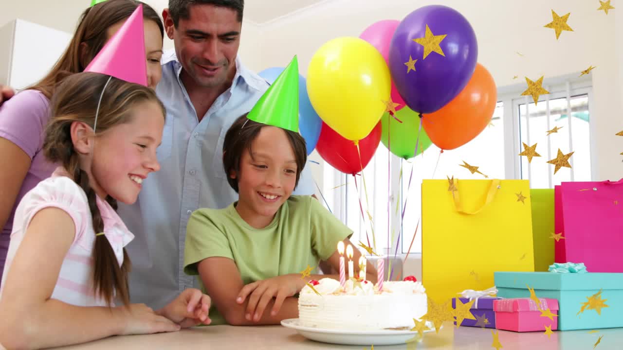 Parents encouraging kids blowing birthday cake candles, confetti rising and balloons drifting