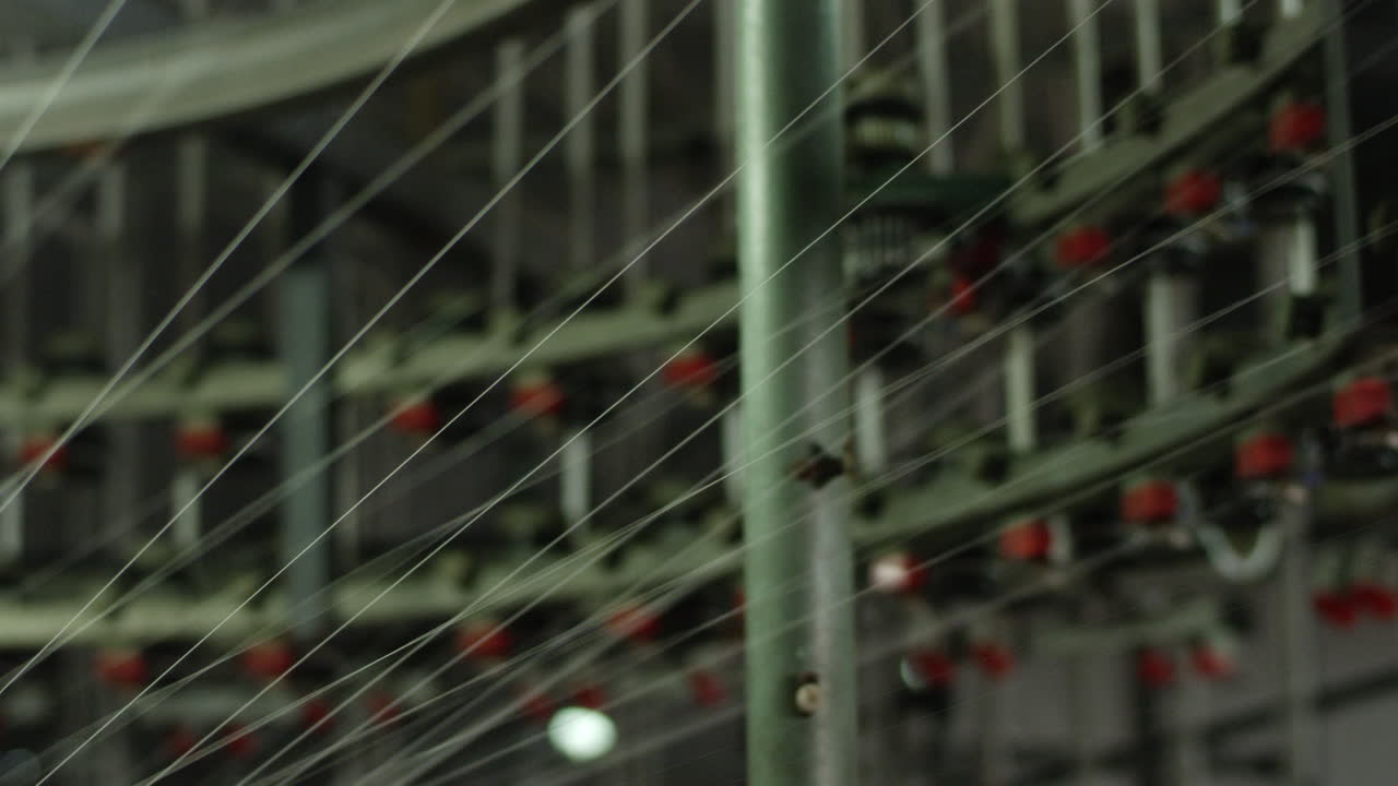 maquinaria de tejido de algodón automatizada en funcionamiento con numerosos hilos de algodón tirados en el interior en una fábrica textil en china