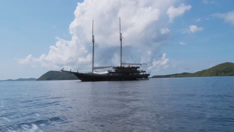large schooner on calm tropical waters with islands