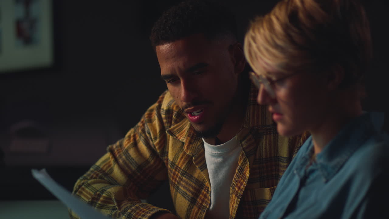 사무실 의 책상 에 있는 두 사업 동료 가 함께 컴퓨터 프로젝트 에서 늦게 일 하는 장면