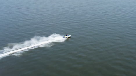 Drone-Shot-of-Man-Jet-Skiing-on-Ocean-in-Mississippi-on-Clear-Sunny-Day