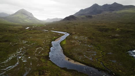 el viento sopla visiblemente sobre el río sligachan con las montañas cuillin en el fondo