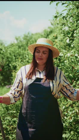 a joyful gardener enjoying her day in the sun surrounded by lush greenery, wearing a straw hat and apron, bringing life to her garden