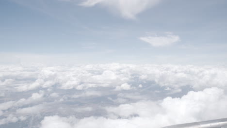 4k-Dolly-Rein-Und-Raus-Aus-Dem-Inneren-Eines-Fliegenden-Flugzeugs-Zum-Fenster,-Um-Den-Blauen-Himmel-Und-Die-Weißen-Wolken-Zu-Sehen