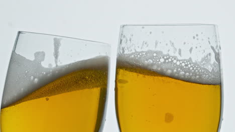 bubbly beer two glass clinking white background. alcohol goblets making toast