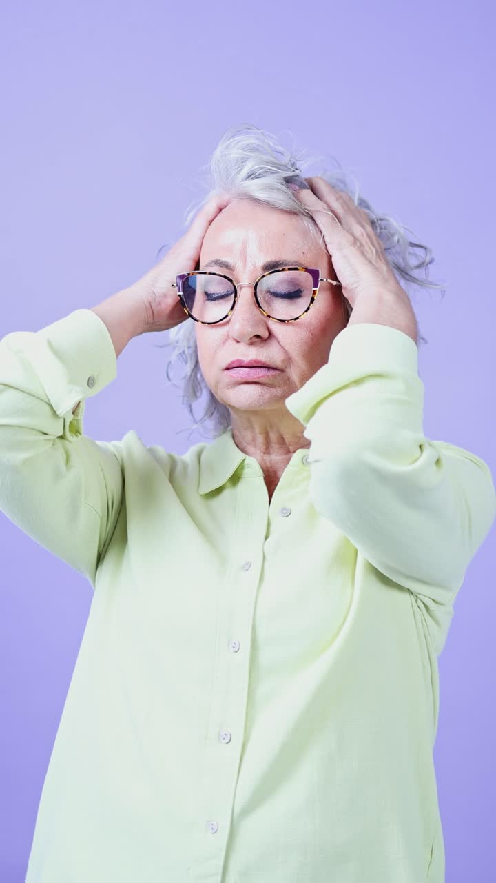 Mature Woman Holding Her Head in Pain and Distress