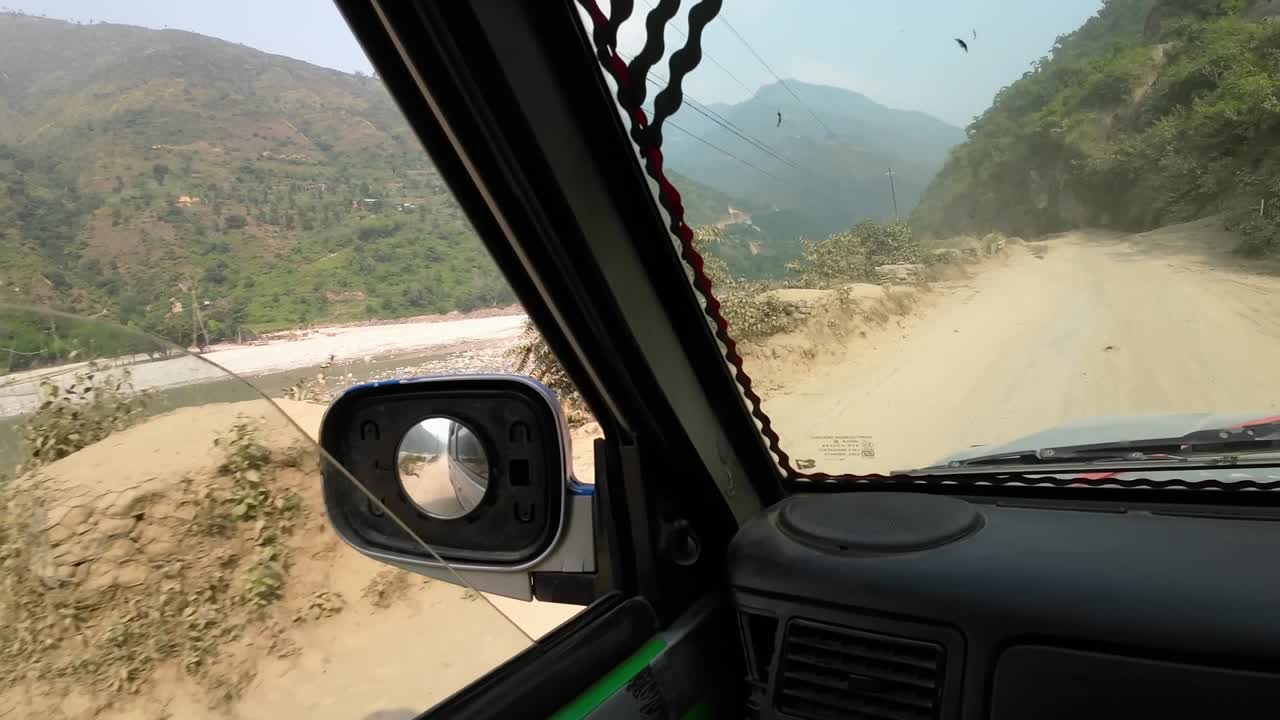 POV jeep ride through Nepal's rugged interior. Camera pan to the side down onto the deep valley and Sunkoshi River