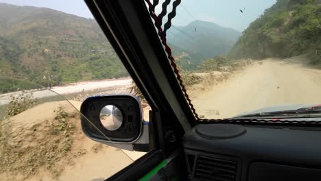 pov jeep ride through nepal's rugged interior. camera pan to the side down onto the deep valley and sunkoshi river