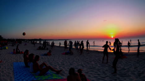 people enjoying sunset activities on a crowded beach