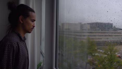 a man looking sad and thoughtfull, looking out over the city of amsterdam