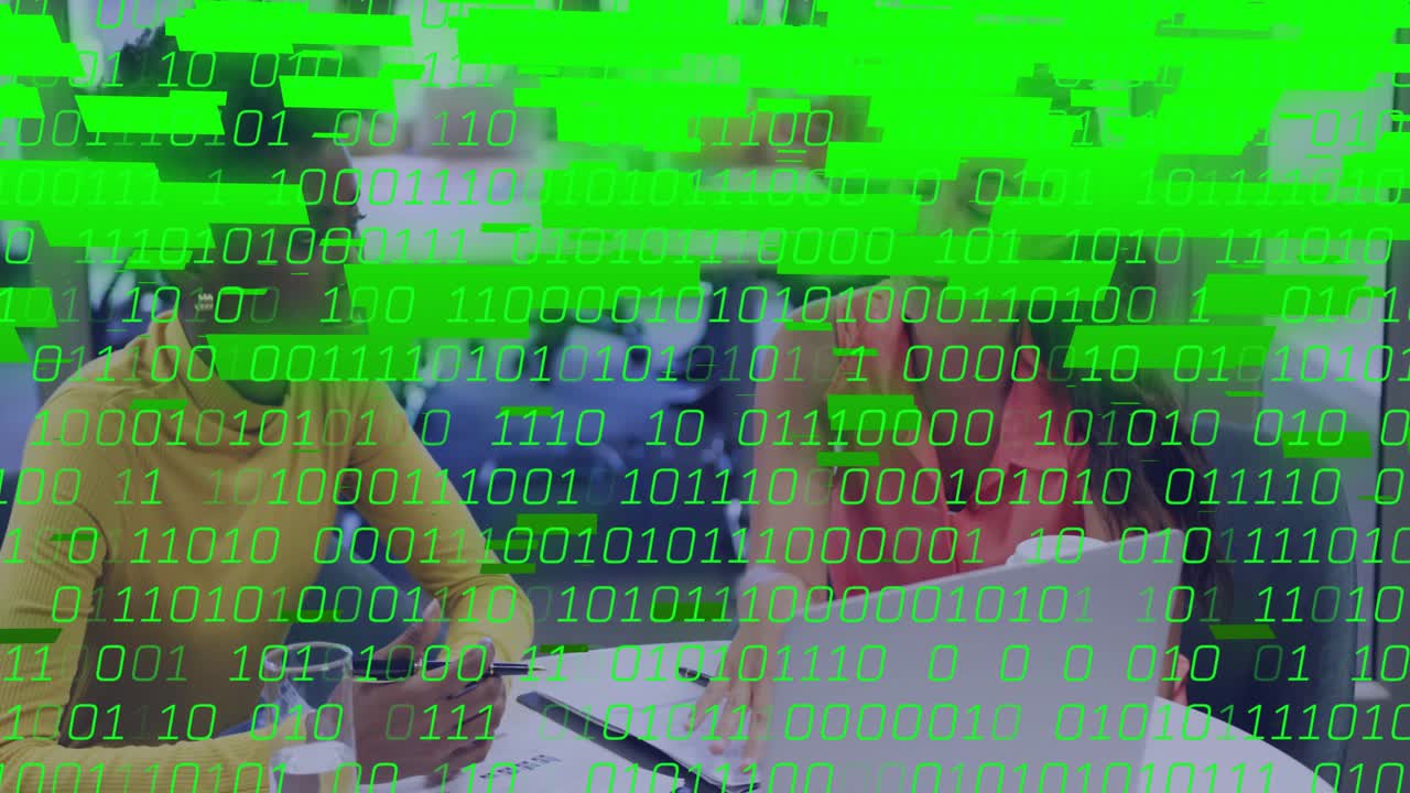 Un présentateur dépliant son ordinateur portable pour discuter de données techniques, avec un code binaire vert qui défile tandis qu'un auditeur prend des notes