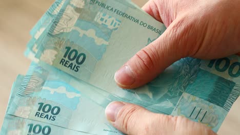 dinero brasileño, reales, contando billetes de alto valor
