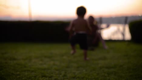 latin baby boy walking on the grass having fun at dusk