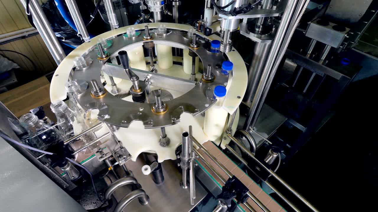 los rellenadores y tapadores automáticos trabajan en la fábrica de leche.