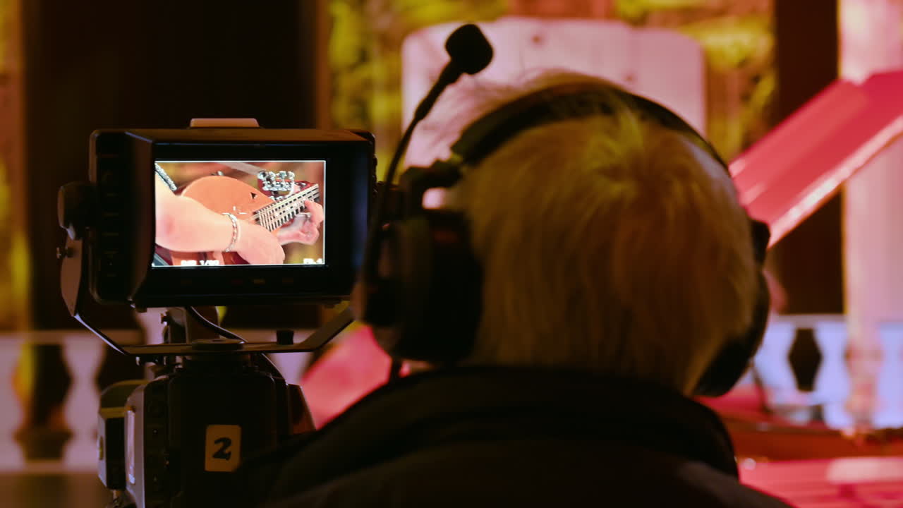 Man filming with professional camera on the backstage of a TV set